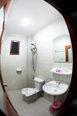 a bathroom with a sink and a toilet and a mirror at Freedom Hotel in Patong Beach