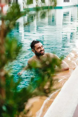 a man swimming in a swimming pool at Casa Del M Patong Phuket in Patong Beach