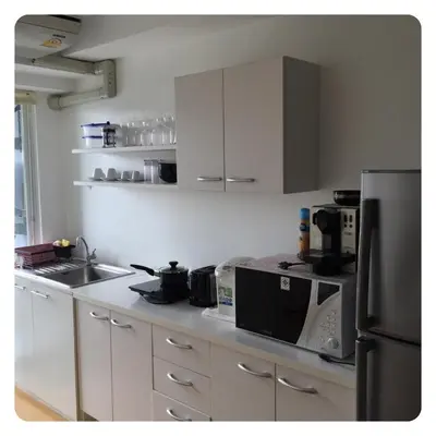 a kitchen with white cabinets and a black refrigerator at Apartment in Ranghill Residence Phuket by month in Phuket Town