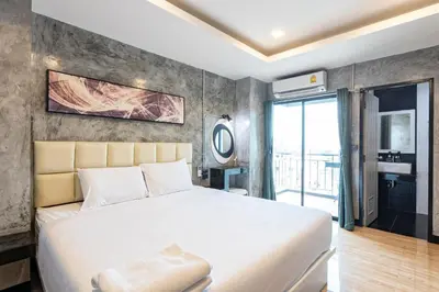 a bedroom with a large white bed and a balcony at My Style Resort Hotel -SHA Plus in Patong Beach