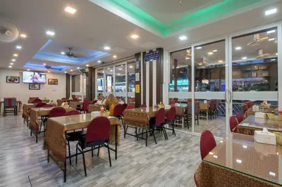 a dining room with tables and chairs in a restaurant at Baan Thai Beach Side Residence, Patong Beach in Patong Beach