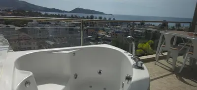 a white bath tub on a balcony with a view at Villa Versace Residence in Patong Beach