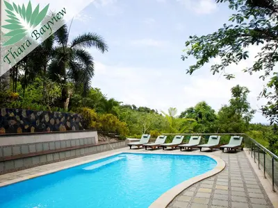 a swimming pool with lounge chairs next to a resort at Thara Bayview Villa, SHA Certified in Ao Nang Beach