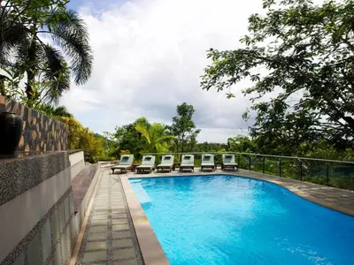 a swimming pool with lounge chairs next to a fence at Thara Bayview Villa, SHA Certified in Ao Nang Beach