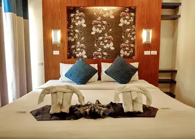 a bedroom with a bed with towels on it at Calypso Patong Hotel in Patong Beach