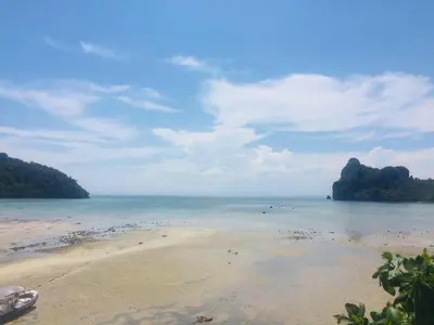 a beach with a view of the water and mountains at The One Hostel Phi Phi Island in Phi Phi Don