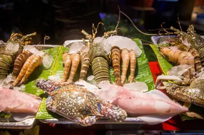 a bunch of different types of seafood on a tray at Kata Poolside Resort SHA Extra Plus in Kata Beach