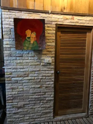 a painting on a brick wall next to a door at Fisherman Guesthouse in Ko Yao Noi