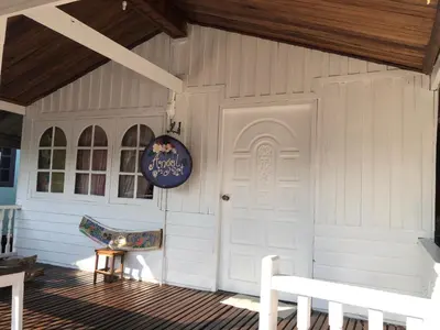 a white house with a white door and a bench at Fisherman Guesthouse in Ko Yao Noi