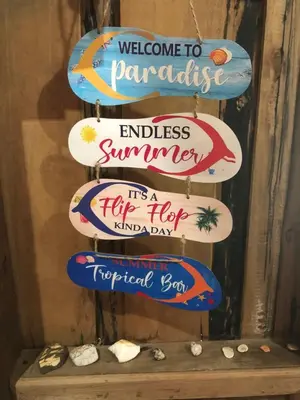 a group of signs that say welcome to paradise and endless summer at Fisherman Guesthouse in Ko Yao Noi