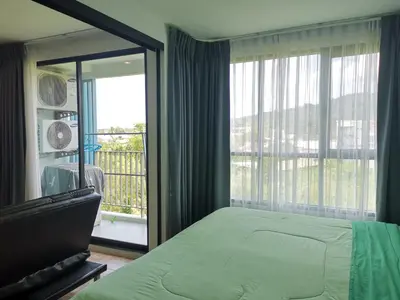 a bedroom with a bed and a large window at 5 Floor - Centrio Condominium in Phuket Town - 30 mins to beaches in Phuket Town