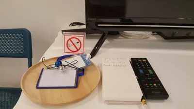a desk with a table with a remote control at Wora Stay room Kata beach in Kata Beach