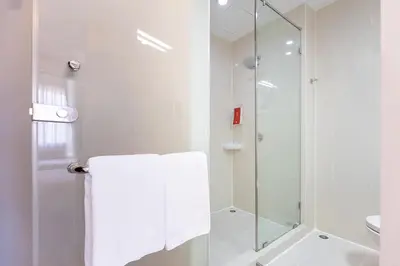 a white bathroom with a shower and a toilet at Easy Planet Phuket Patong in Patong Beach
