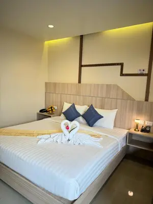 two white swans are sitting on a bed at The Way Patong Hotel in Patong Beach