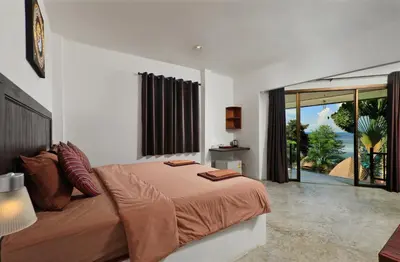 a bedroom with a bed and a large window at The Cove Phi Phi in Phi Phi Don