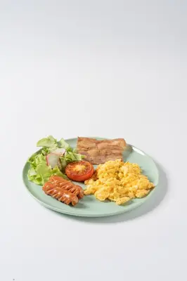 a plate of breakfast food with eggs meat and vegetables at Sugar Ohana Poshtel in Kata Beach