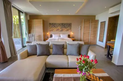 a living room with a couch in front of a bed at Ocean Rock Kalim in Patong Beach