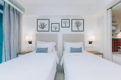 two beds in a white room with pictures on the wall at Sugar Marina Hotel - NAUTICAL - Kata Beach in Kata Beach