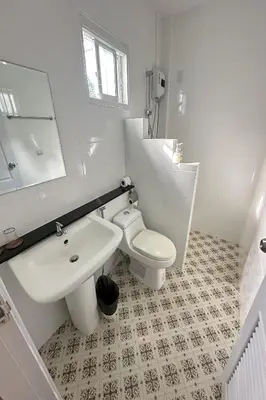 a white bathroom with a sink and a toilet at Be Leaf Resort SHA in Thalang