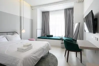 a bedroom with a bed and a desk and a chair at Our Nomad Boutique Hostel in Phuket Town