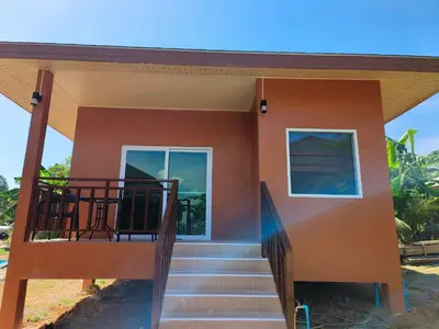 a house with a staircase leading to the front door at Sunrise Beach Kohyao Resort in Ko Yao Yai