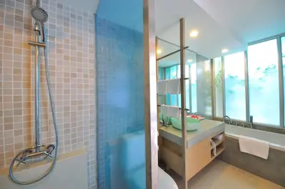 a bathroom with a shower and a sink and a mirror at Ramada by Wyndham Phuket Southsea in Karon Beach