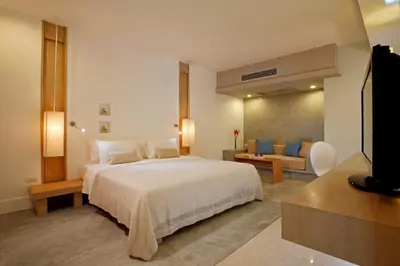 a bedroom with a large bed and a television at Ramada by Wyndham Phuket Southsea in Karon Beach