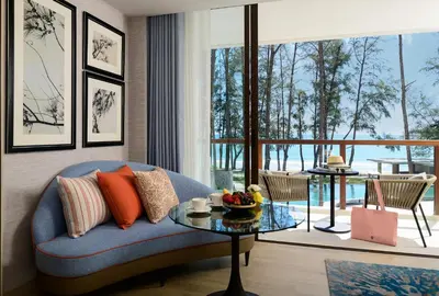 a living room with a blue couch and a table at InterContinental Phuket Resort by IHG in Kamala Beach
