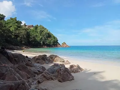 a beach with large rocks and the ocean at Naiyang Beach Hotel SHA Plus in Nai Yang Beach