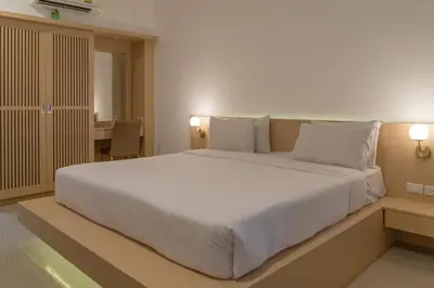 a bedroom with a large bed with white sheets and pillows at Garden Home Kata in Kata Beach