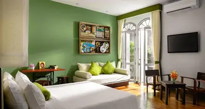 a green room with two beds and a couch at The Memory at On On Hotel in Phuket Town