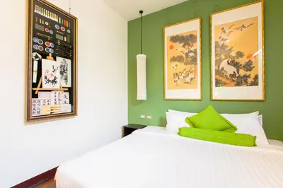 a bedroom with a green accent wall and a bed at The Memory at On On Hotel in Phuket Town