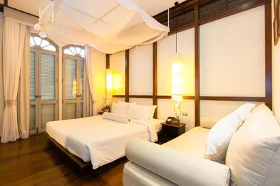a bedroom with two beds and a couch at The Memory at On On Hotel in Phuket Town