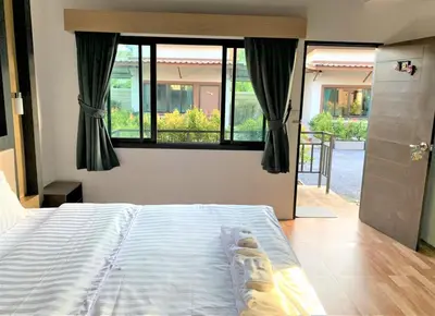 a bedroom with a bed and a large window at Thalang resort in Thalang