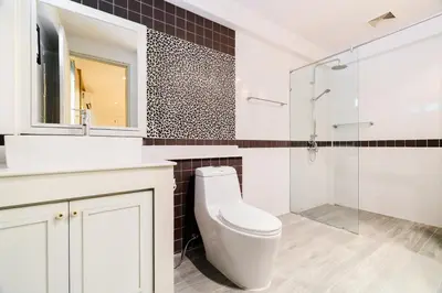 a bathroom with a toilet and a glass shower at Villa Pimmada in Ao Nang Beach