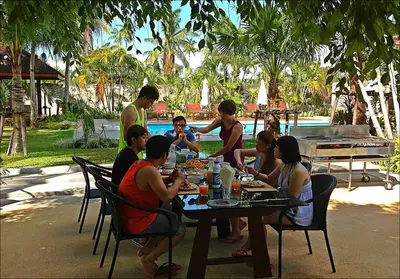a group of people sitting at a table eating food at Villa Pimmada in Ao Nang Beach
