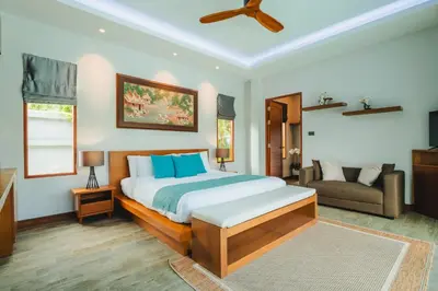 a bedroom with a large bed and a couch at Bangtao Boutique Villa in Bang Tao Beach