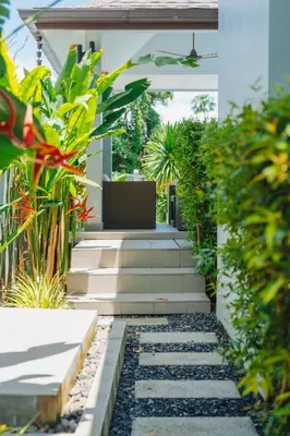 a garden with stairs and plants in front of a house at Bangtao Boutique Villa in Bang Tao Beach