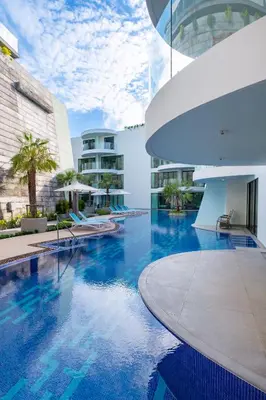 a swimming pool with blue water in a building at Absolute Twin Sands Resort & Spa - SHA Extra Plus in Patong Beach