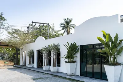 a white building with potted plants in front of it at The Loft Panwa Resort in Panwa Beach