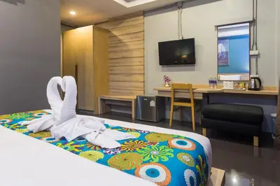 a hotel room with a bed with a towel animal on it at Memory Boutique Patong in Patong Beach