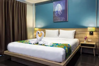 a bedroom with a bed with two swans on it at Memory Boutique Patong in Patong Beach