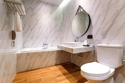 a bathroom with a toilet and a sink and a mirror at The Palmery Resort in Kata Beach