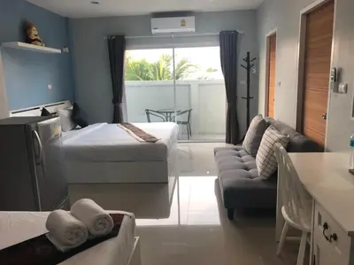 a hotel room with two beds and a couch at Khao Oat airport in Nai Yang Beach