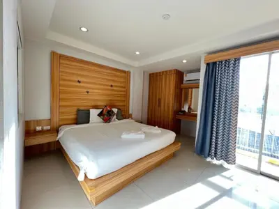a bedroom with a large bed and a large window at Cat Story Hotel in Patong Beach