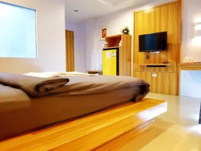 a bedroom with a bed and a flat screen tv at Cat Story Hotel in Patong Beach