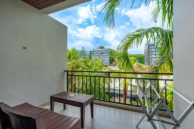 a balcony with a table and a view of a city at Anchan Boutique Hotel in Chalong