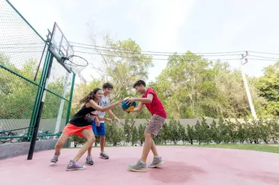 a group of people playing basketball on a court at Anantara Vacation Club Mai Khao Phuket in Mai Khao Beach