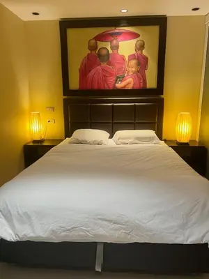 a bedroom with a large bed with a painting on the wall at Luxury Apartment Kata Beach The Accenta in Kata Beach