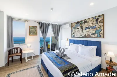 a bedroom with a large bed with a painting on the wall at Waterfront Karon Beach by PHR in Karon Beach